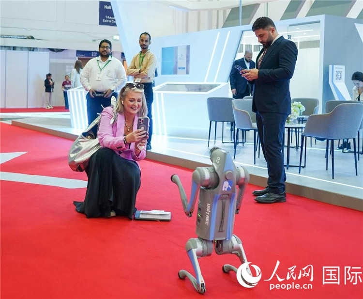 與會(huì)嘉賓被中企機(jī)器人吸引。人民網(wǎng) 塔里克·易卜拉欣攝