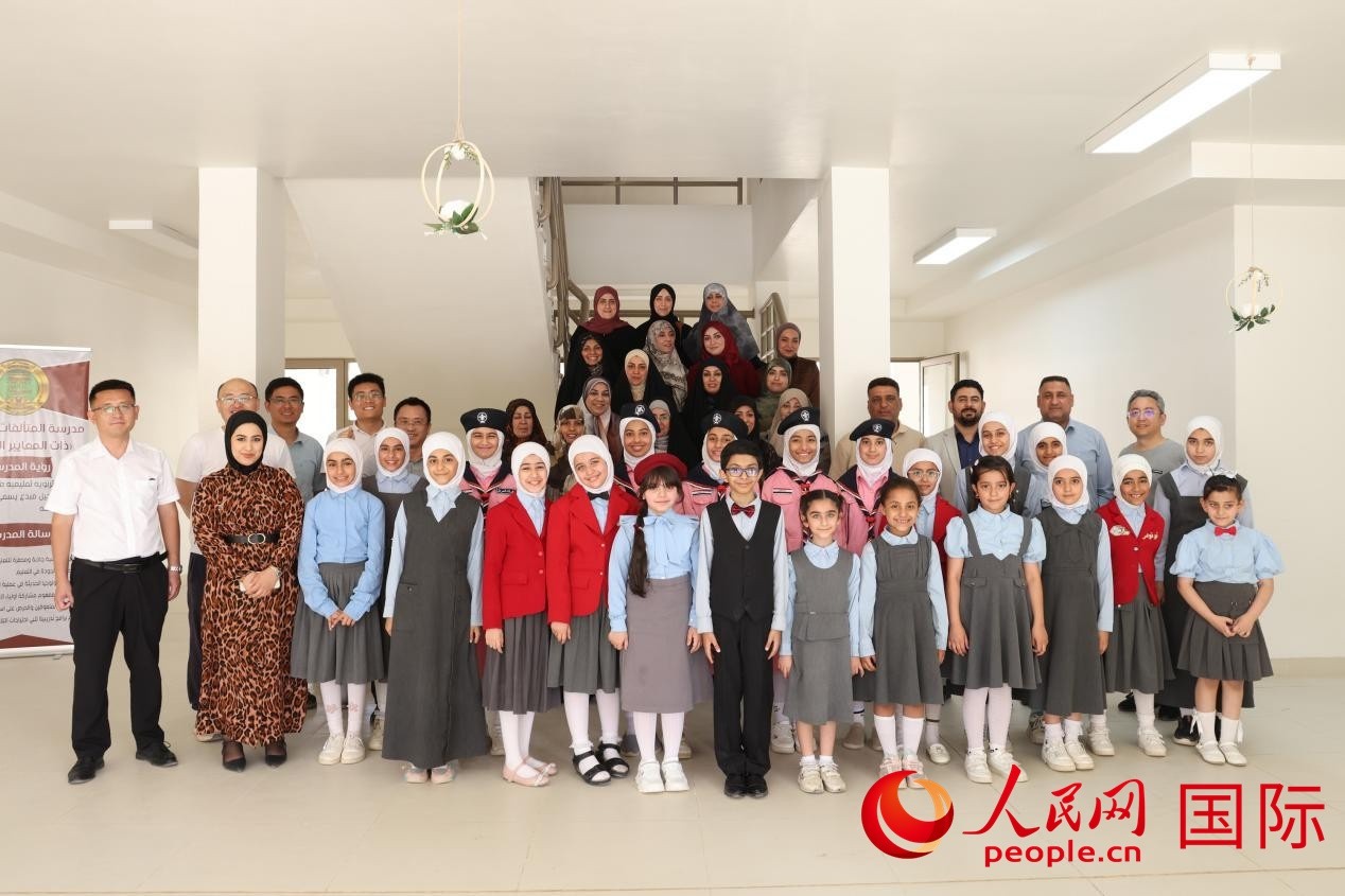 中國電建員工與阿爾穆塔?阿里卡特國際學校的師生及政府官員等合影。人民網記者 薛丹攝