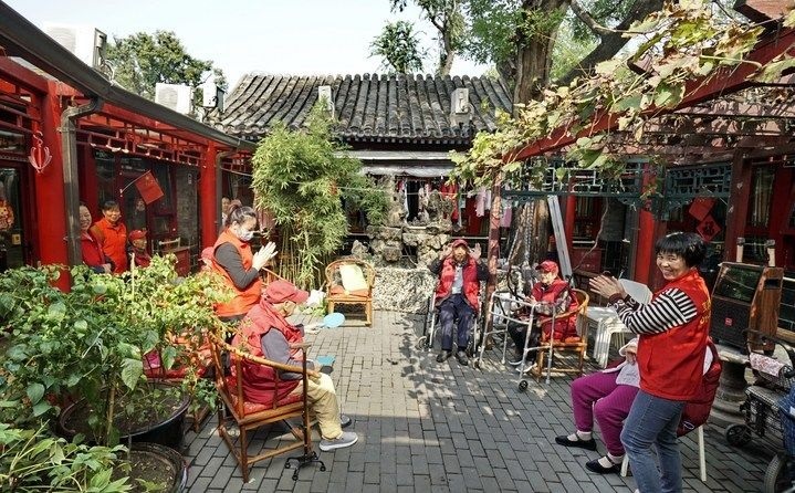 2024年10月12日，鐘樓灣胡同的老年人在社區(qū)內(nèi)的四合院養(yǎng)老驛站休閑。2017年起，北京市先后開展了兩輪背街小巷環(huán)境整治提升行動(dòng)，完整保留了中軸線生活建筑群的歷史信息，并根據(jù)居民的生活和居住方式進(jìn)行適配化的更新和改造，極大地改善了生活環(huán)境。2023年鐘樓灣胡同被評(píng)為“北京最美街巷”。