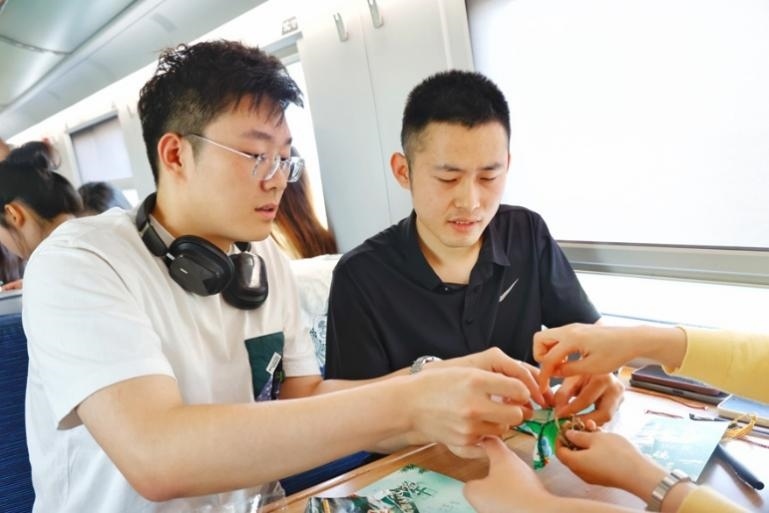 G232次旅客親手制作端午荷包和五彩繩。王磊攝