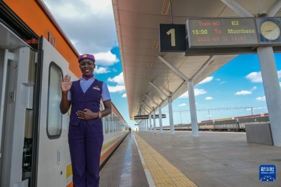 5月31日，在蒙內鐵路內羅畢站，一名乘務員在即將開往蒙巴薩的E2次列車旁等候乘客。新華社記者 楊光 攝