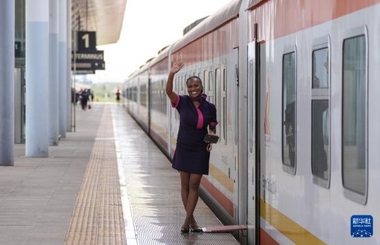 5月31日，在蒙內鐵路內羅畢站，一名乘務員在即將開往蒙巴薩的E2次列車旁等候乘客。新華社記者 李亞輝 攝