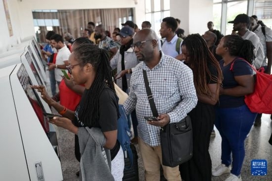 5月31日，在蒙內鐵路內羅畢站，乘客在自助取票機前排隊取票。新華社記者 楊光 攝