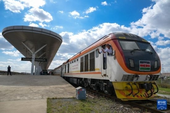 5月31日，在蒙內鐵路內羅畢站，機車駕駛員蔣立平（右）和博爾在即將開往蒙巴薩的E2次列車上揮手致意。新華社記者 楊光 攝