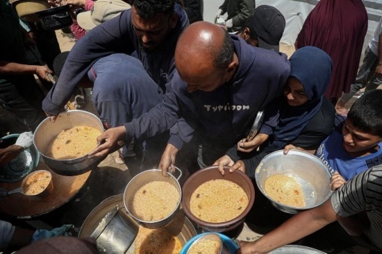 5月28日，人們?cè)诩由吵俏鞑康纳程犭y民營(yíng)領(lǐng)取救助食物。新華社發(fā)（里澤克·阿卜杜勒賈瓦德攝）