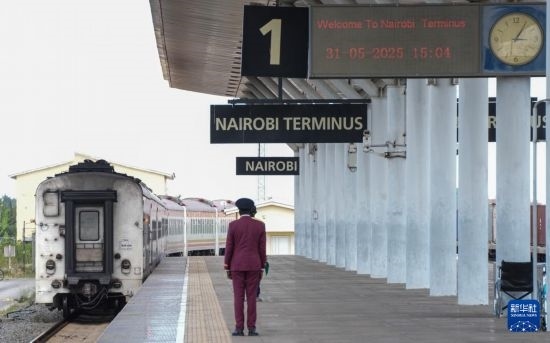 5月31日，在蒙內鐵路內羅畢站，工作人員目送開往蒙巴薩的E2次列車駛離站臺。新華社記者 李亞輝 攝