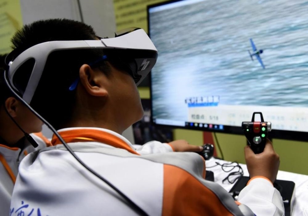 北京市八一學(xué)校的學(xué)生在北京市中小學(xué)生特色科技活動(dòng)展示上體驗(yàn)VR技術(shù)（2018年11月24日攝）新華社記者 羅曉光 攝。
