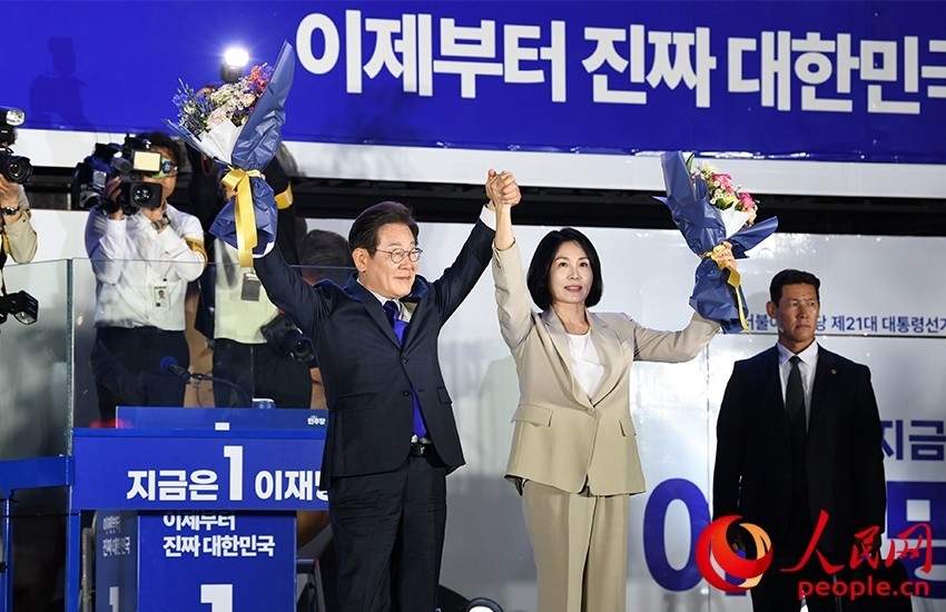 6月4日凌晨，確定當(dāng)選韓國(guó)總統(tǒng)的李在明舉手向歡呼的支持者們致意。 人民網(wǎng) 康炯彬攝