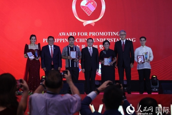 黃溪連大使和菲中了解協(xié)會主席與榮獲“友誼獎”的獲獎者合影留念。人民網(wǎng)記者 樊帆攝